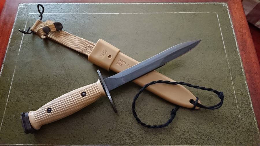 M7 Bayonet USMC, SUPER RARE, desert tan version of the original, legendary M7 bayo. Late production run (circa 1989-90), was issued to a handful of Elite US Task- Forces during Desert Storm Operation, before the M9s took completely over in the Gulf War. Rest of production of these later aimed at the civilian market where they fetched top-$$ due to unique design & limited supply.
Absolutely no signs of use on this one, just Army storage grease! It comes with latest M10 polymer sheath. Strong, Sharp, Slick & Authentic!