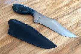 Darkwing Blades Custom double edged fighter, Darkwing Blades custom fighter made by De Wet van Zyl, 18cm blade with a 15cm main edge and 10cm back edge

Steel is 1095 with hamon (differential heat treatment) with G10 handle 

Knife comes with a custom leather sheath

R1600 price includes shipping postnet to postnet